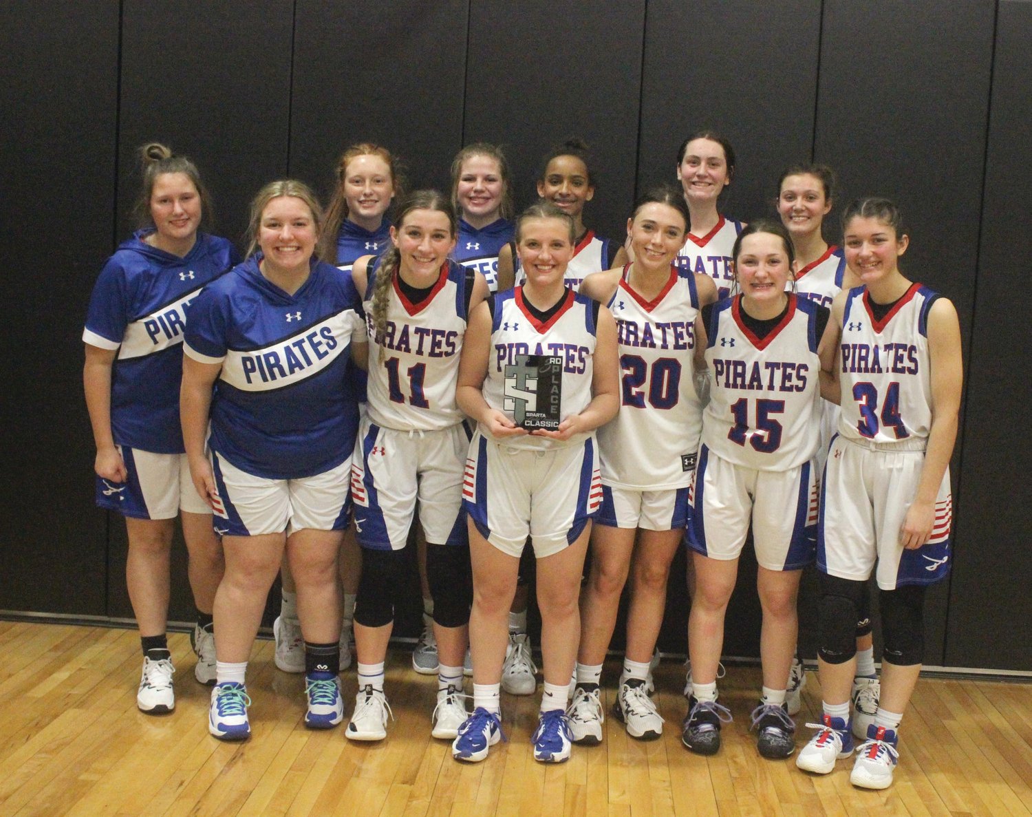 The Norwood Lady Pirates’ girls basketball team with their third place trophy after defeating Hartville in the Sparta Lady Trojans Classic on Saturday.